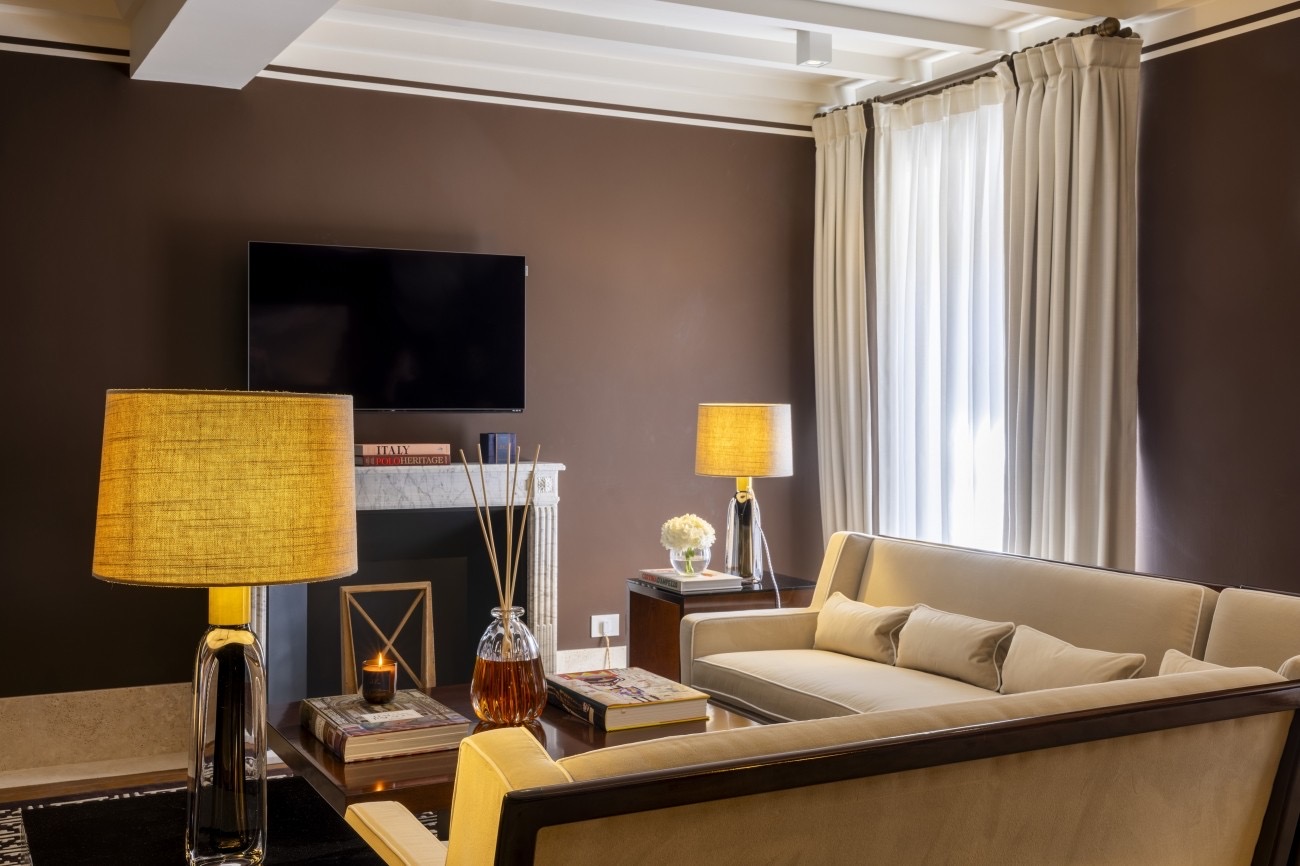 Luxurious living space featuring a beige sofa, warm lighting, a modern television, and elegant decor in Casa J.K. Place Roma.