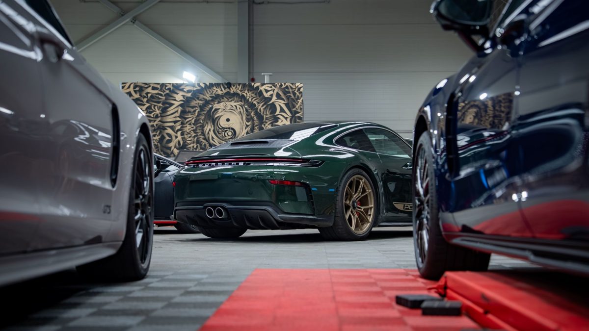 Luxury garage condos showcasing a green Porsche surrounded by other high-end vehicles in a stylish interior.