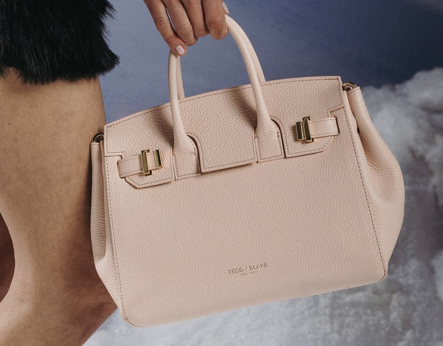 Stylish blush pink handbag with structured design and gold accents, perfect for elevated essentials this Labor Day weekend.