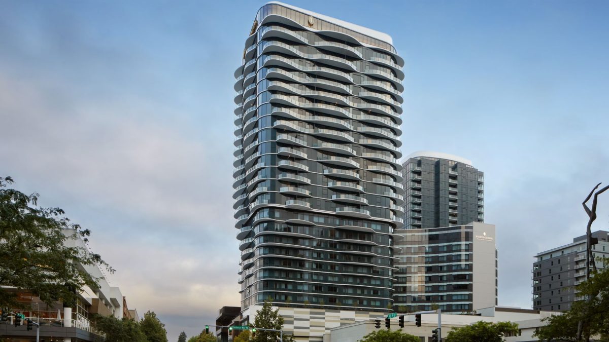 Modern luxury hotel building in Bellevue, showcasing sleek design and glass architecture against a cloudy sky.