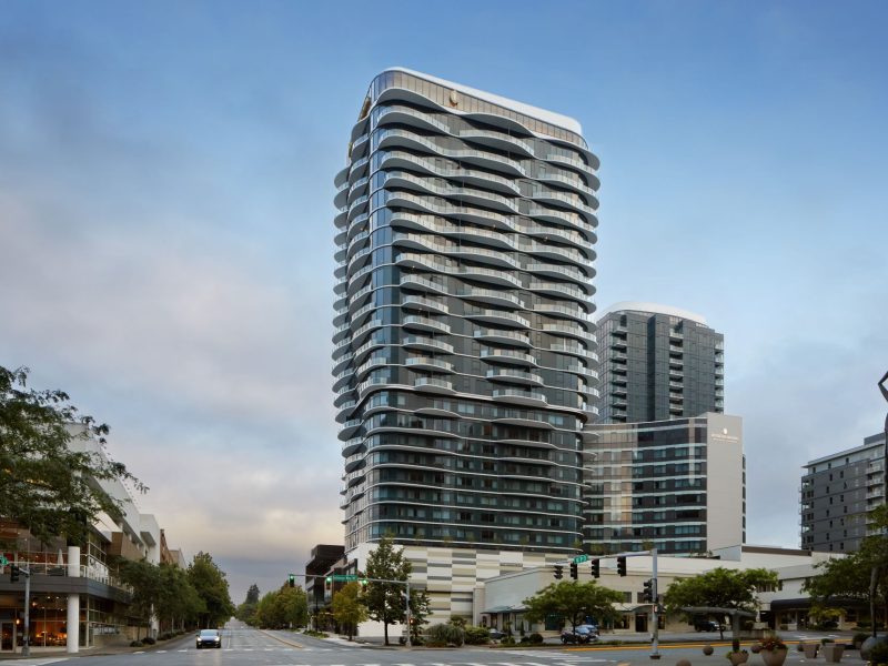 Modern luxury hotel building in Bellevue, showcasing sleek design and glass architecture against a cloudy sky.