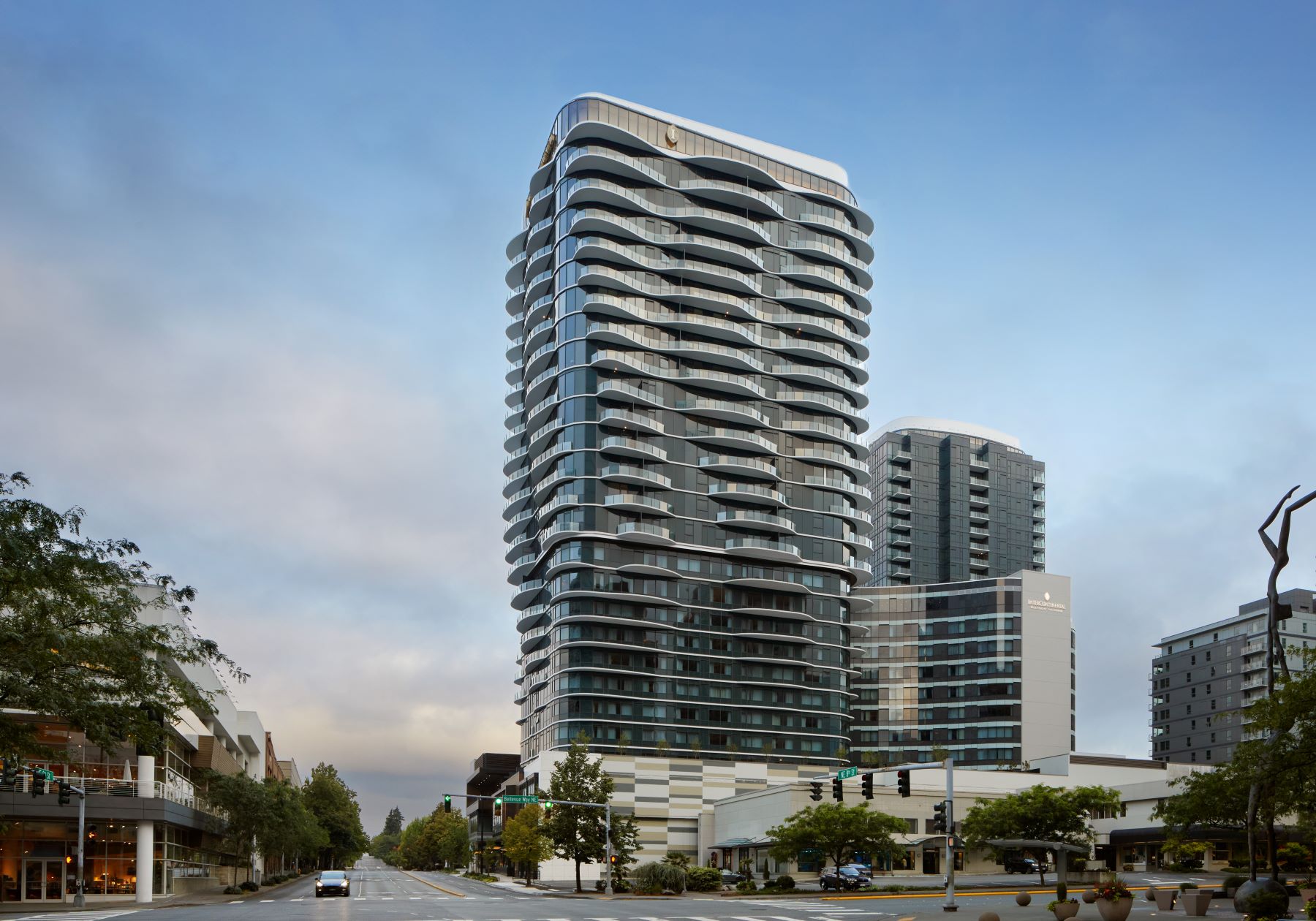 Modern luxury hotel building in Bellevue, showcasing sleek design and glass architecture against a cloudy sky.