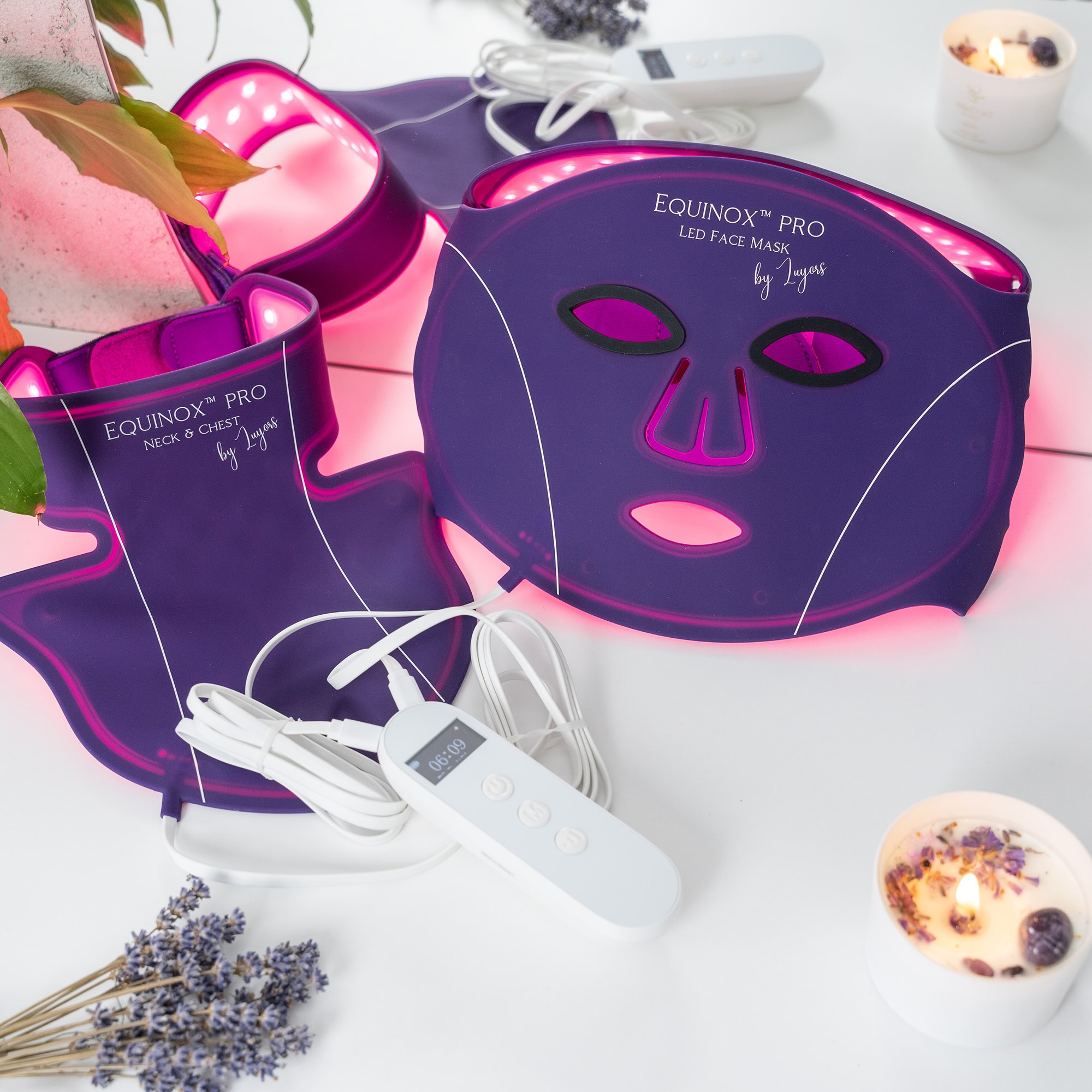 LED face mask and neck treatment by Equinox, featuring purple design with glowing lights, control remote, and relaxing ambiance.