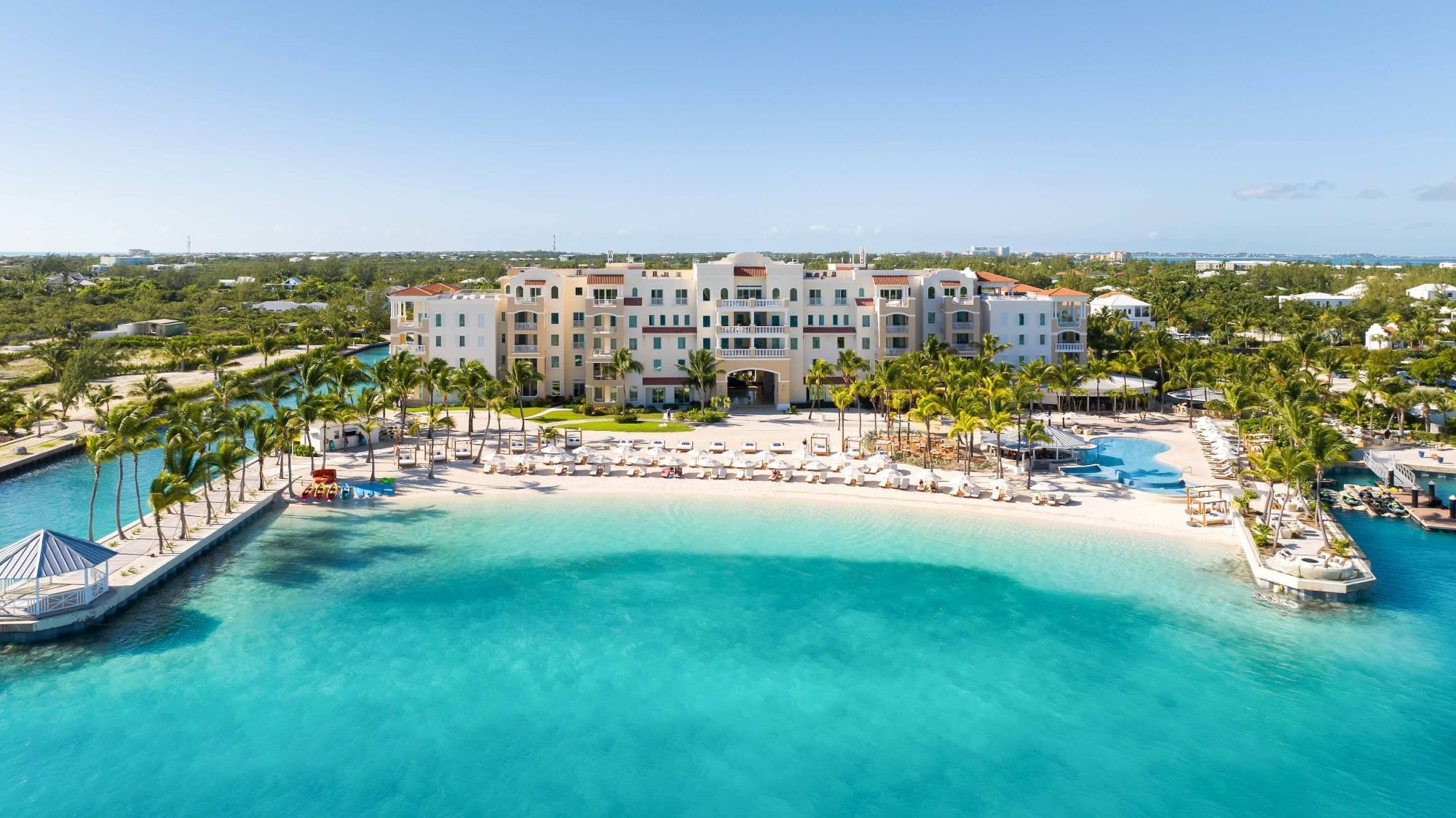 Aerial view of Blue Haven Resort with white sandy beach, palm trees, and turquoise waters in Turks and Caicos.
