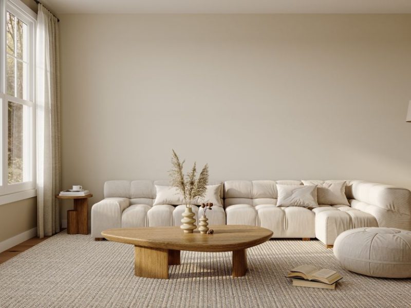 A cozy living room featuring a large, modern sectional sofa, a wooden coffee table, and natural light from large windows.