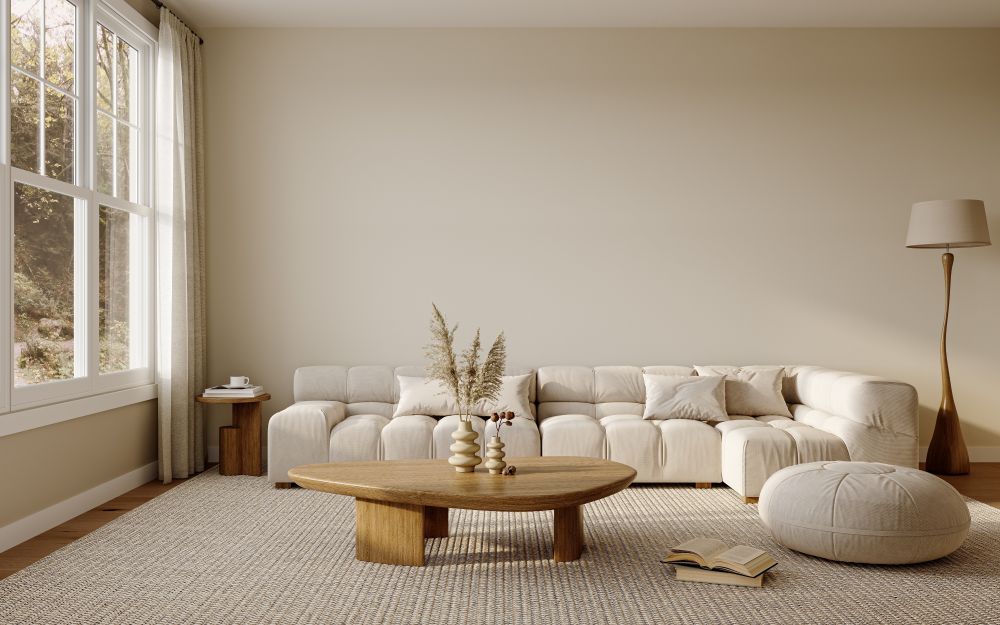 A cozy living room featuring a large, modern sectional sofa, a wooden coffee table, and natural light from large windows.