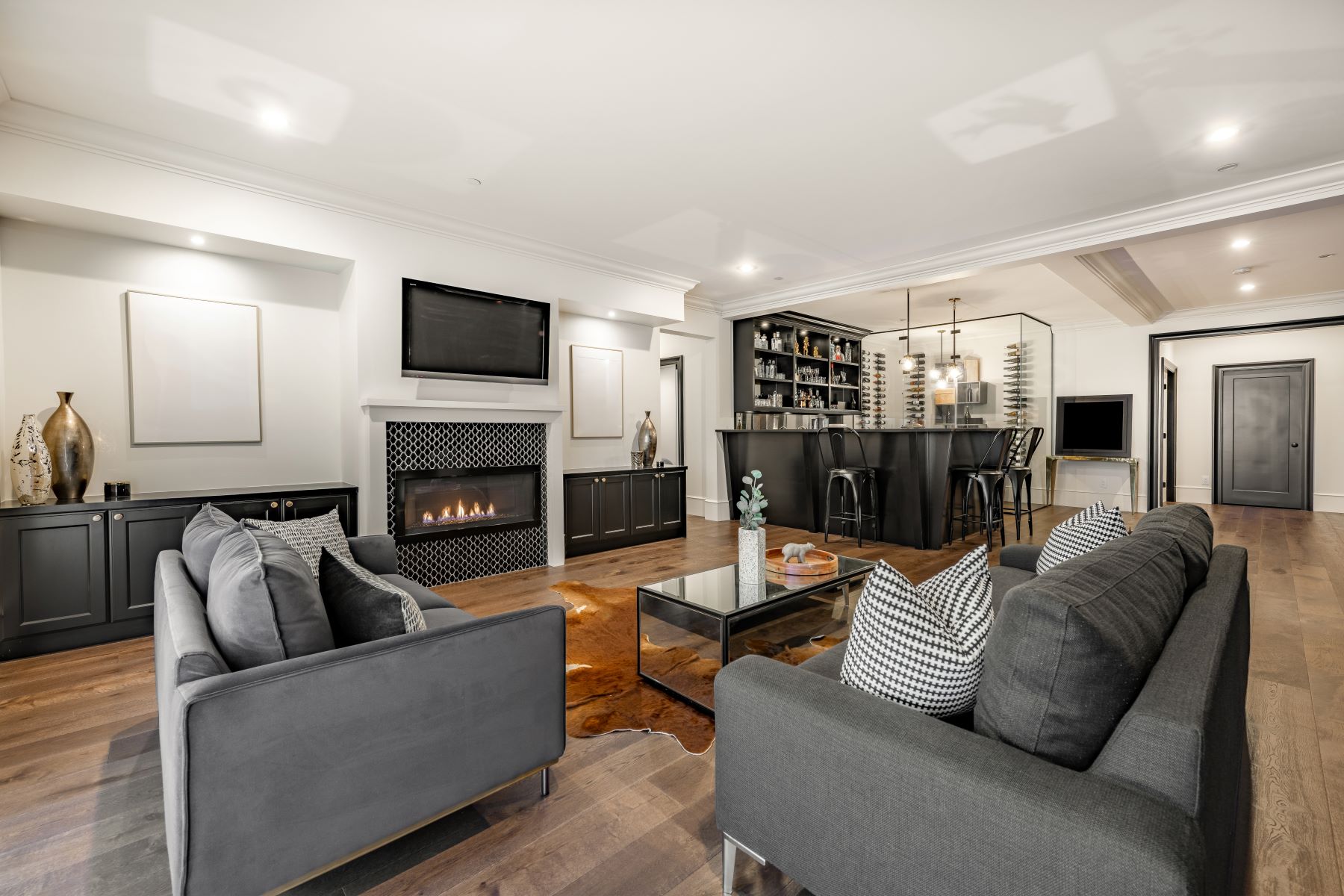 Luxurious living room with a modern fireplace, sleek furniture, and a stylish bar area, creating an inviting atmosphere.