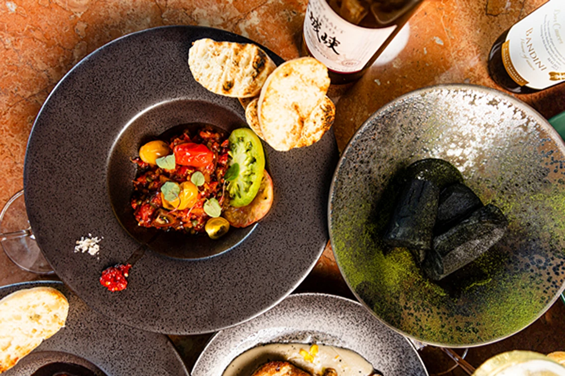 A vibrant array of dishes featuring colorful ingredients, artisan bread, and unique sauces at The Wagyu House.