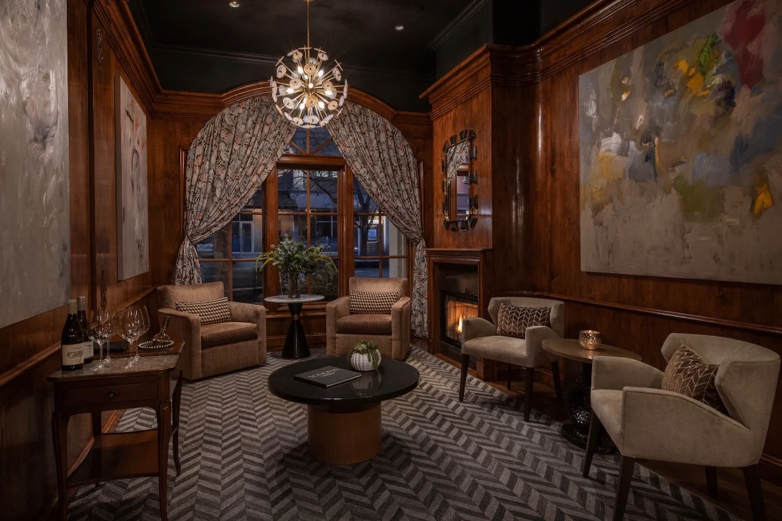 Cozy lounge area with wooden paneling, elegant furnishings, and a fireplace, perfect for wine country retreats.