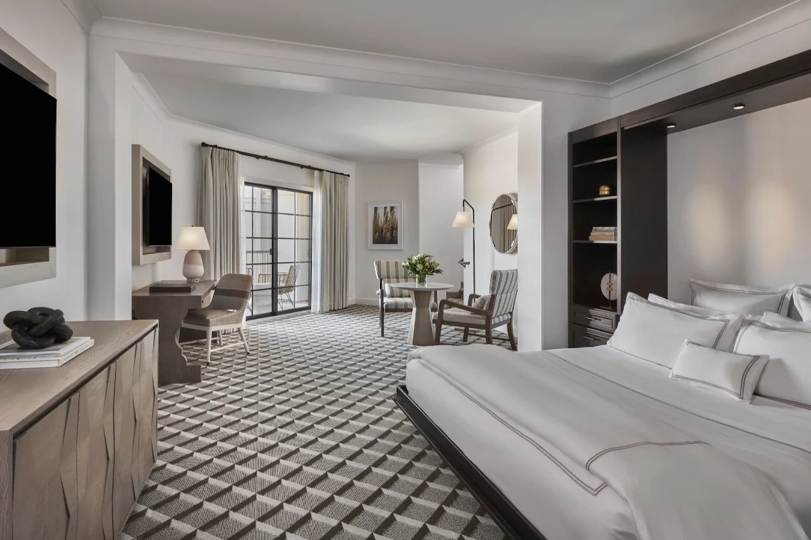 Two-story suite at Meritage Resort, featuring modern furnishings, a bed, sitting area, and large windows with natural light.