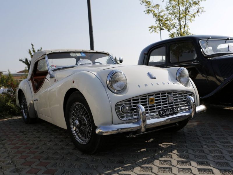 Classic white convertible car parked alongside an antique vehicle at the Finish Line Auto Club in Calabasas.