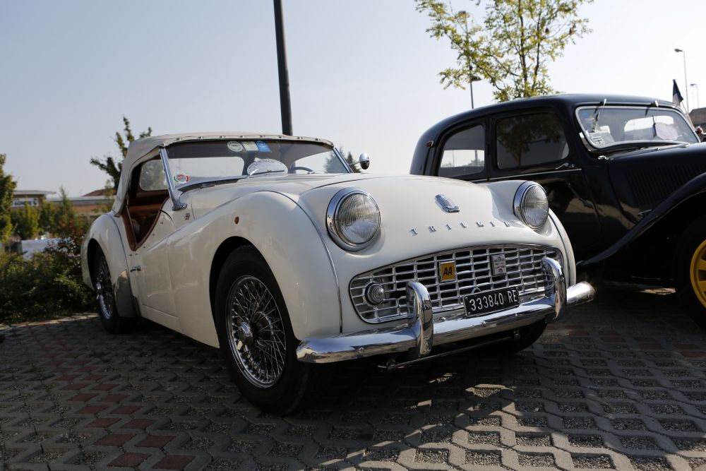 Classic white convertible car parked alongside an antique vehicle at the Finish Line Auto Club in Calabasas.