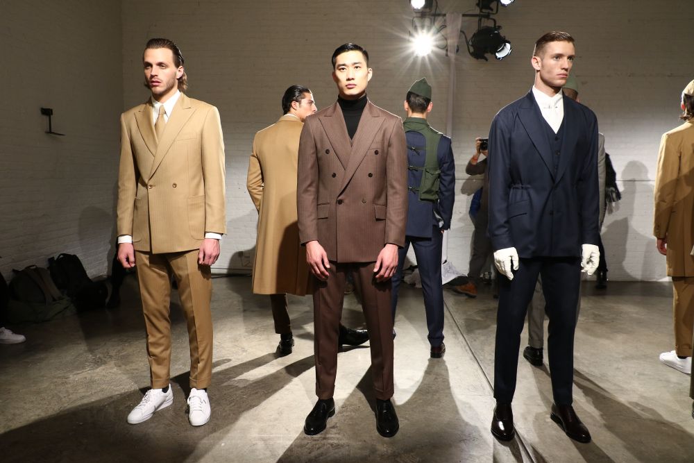 Models showcase the latest luxury menswear in a fashion show, featuring tailored suits in various styles and colors.
