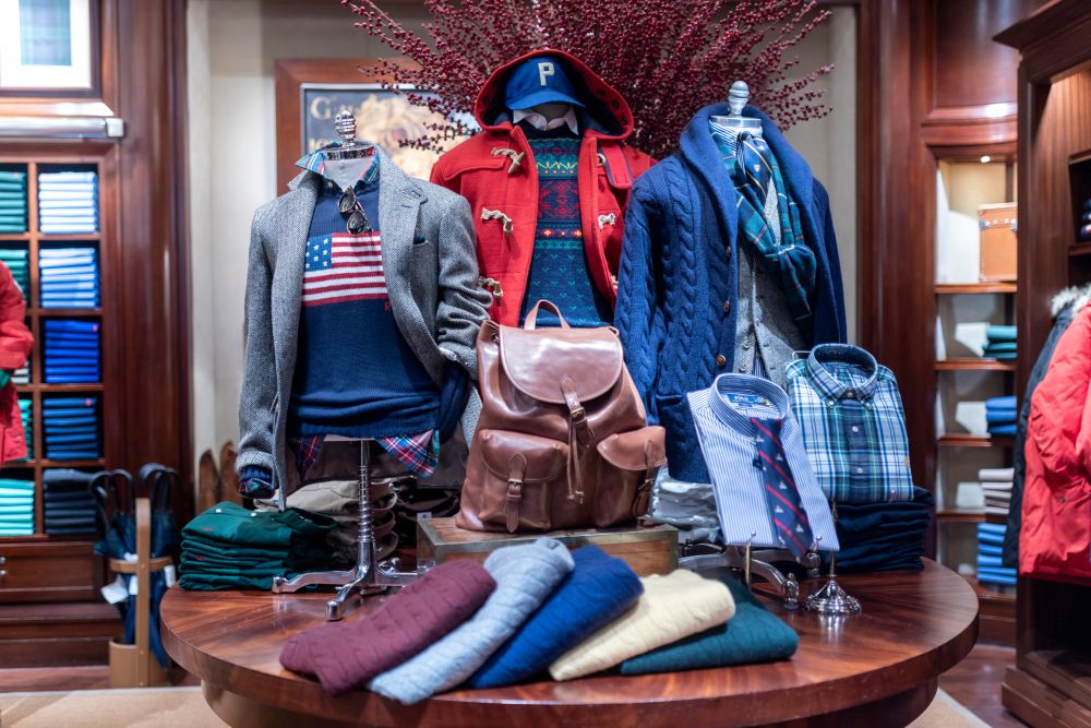 Elegant men's fashion display featuring layered outfits, accessories, and a leather backpack, showcasing fall 2026 luxury style trends.