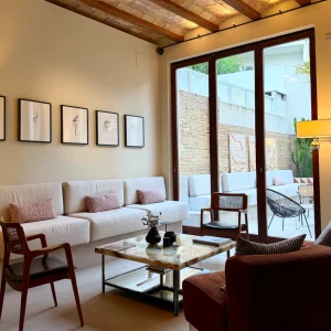 Modernist lounge area at La Novieta hotel featuring a comfortable seating arrangement and large windows overlooking a patio.