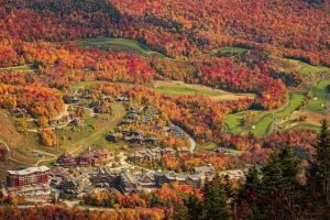 Colorful autumn foliage surrounds the Lodge at Spruce Peak and scenic golf course in Stowe, Vermont.