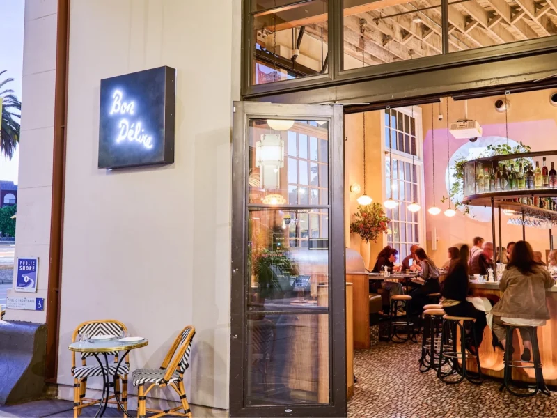 Bon Délire restaurant entrance on San Francisco’s Embarcadero, featuring outdoor seating and lively indoor dining atmosphere.