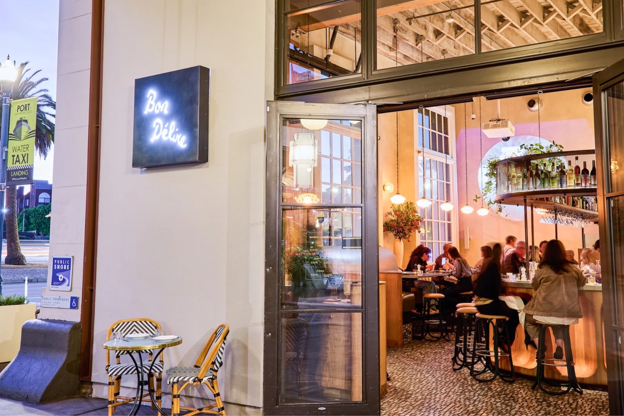 Bon Délire restaurant entrance on San Francisco’s Embarcadero, featuring outdoor seating and lively indoor dining atmosphere.