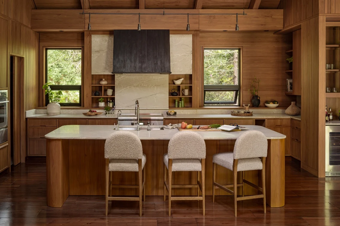 Modern kitchen featuring wood cabinetry, a large island with bar stools, and large windows with natural light.