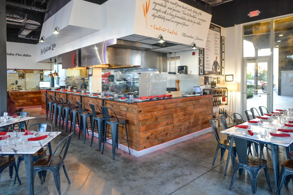 Modern Italian restaurant interior featuring a wood bar, sleek seating, and an open kitchen that merges heritage with innovation.