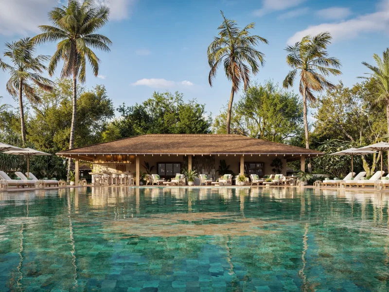 Luxurious pool area at a Nobu resort, featuring palm trees, lounge chairs, and a bar, set against a clear blue sky.