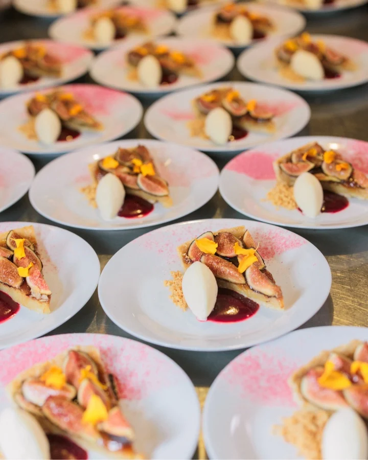 Plates of dessert featuring figs, creamy ice cream, and vibrant garnishes displayed at the James Beard Foundation's Taste America event.