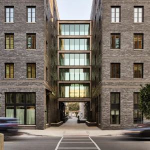 Modern architectural view of The Ann Savannah, featuring a glass entryway between two brick buildings.