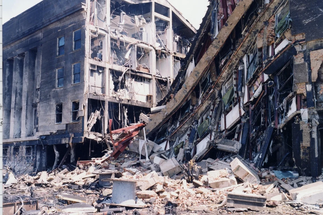 Severely damaged Pentagon building with collapsed sections and debris following the 9/11 attack.
