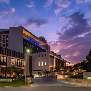 The Amara Hotel exterior showcasing modern architecture against a vibrant sunset sky in Cyprus.