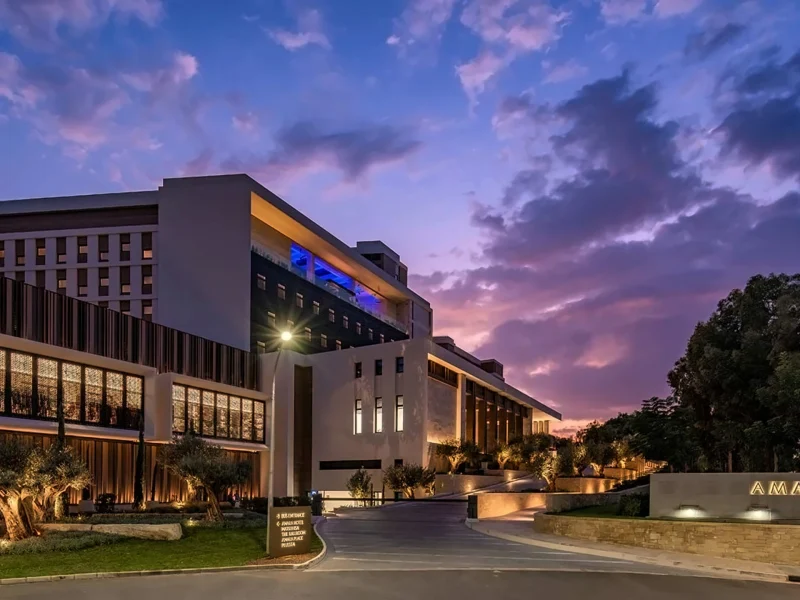 The Amara Hotel exterior showcasing modern architecture against a vibrant sunset sky in Cyprus.