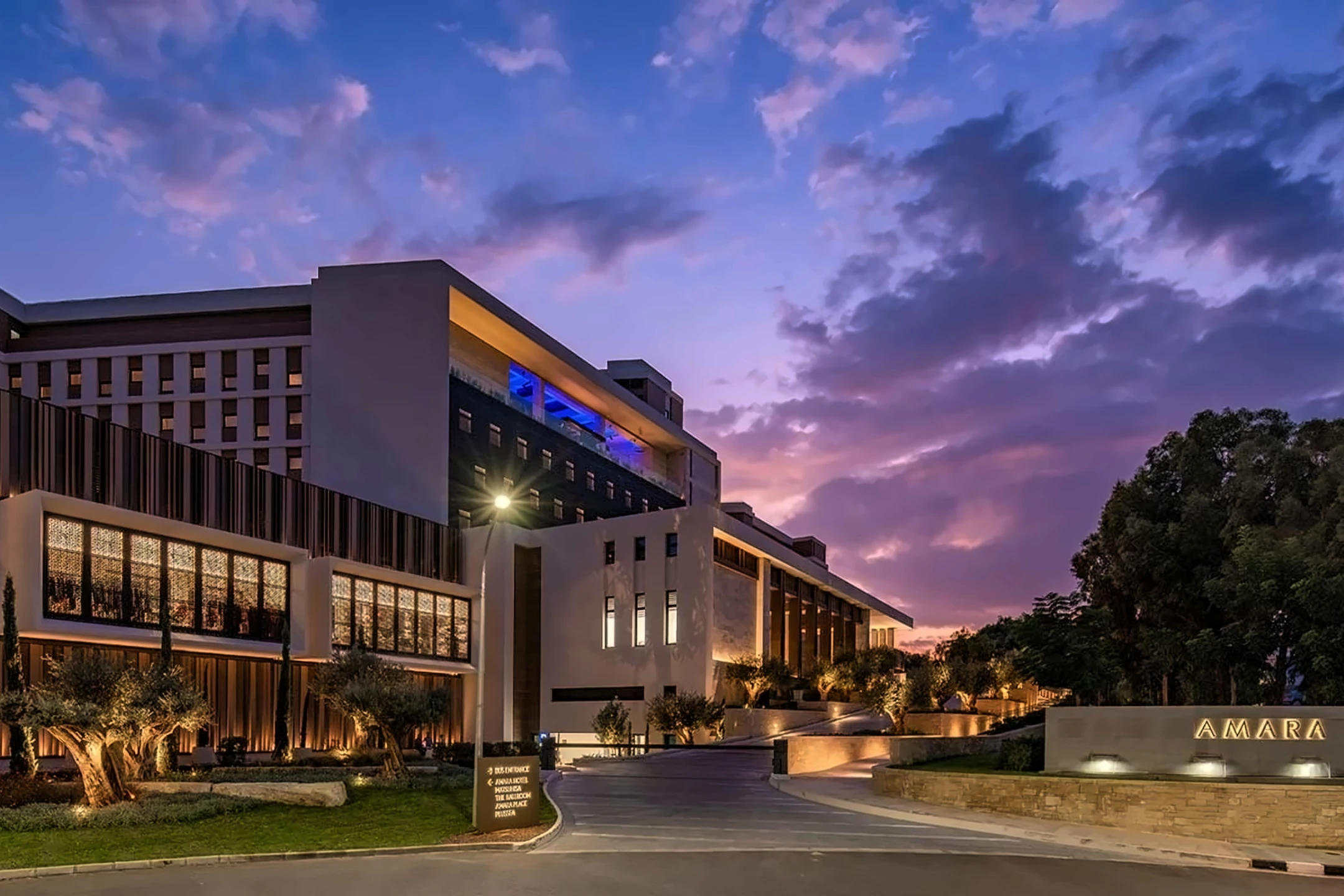The Amara Hotel exterior showcasing modern architecture against a vibrant sunset sky in Cyprus.