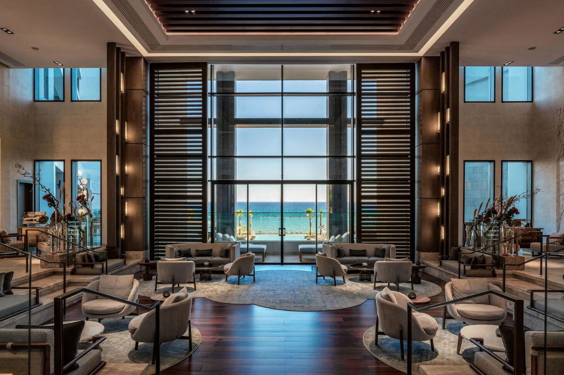 Luxurious hotel lobby interior featuring modern furnishings and large windows overlooking the sea at the AMARA Hotel, Cyprus.