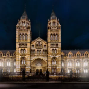 Natural History Museum illuminated at night, showcasing its stunning architecture and lighting design.