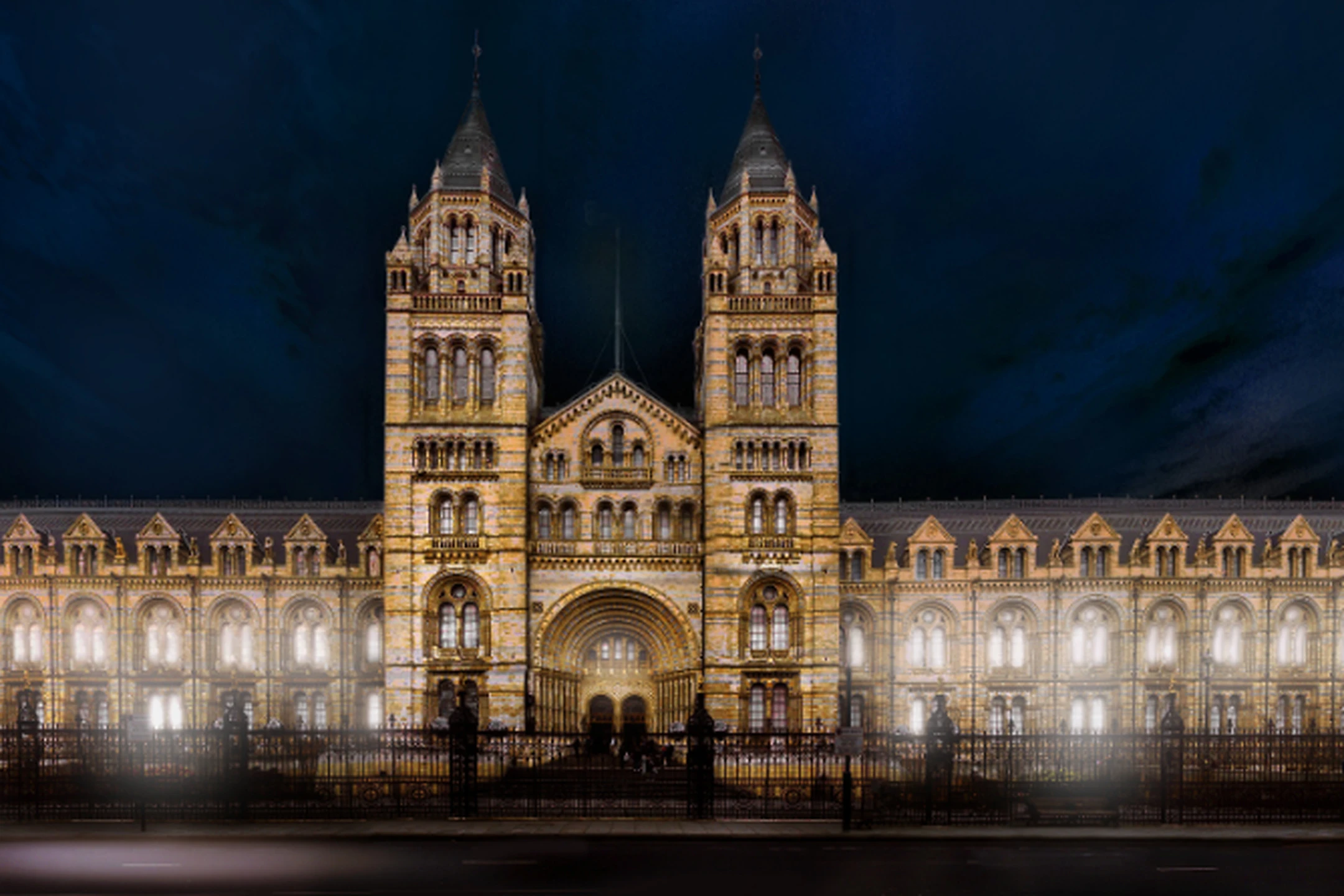 Natural History Museum illuminated at night, showcasing its stunning architecture and lighting design.