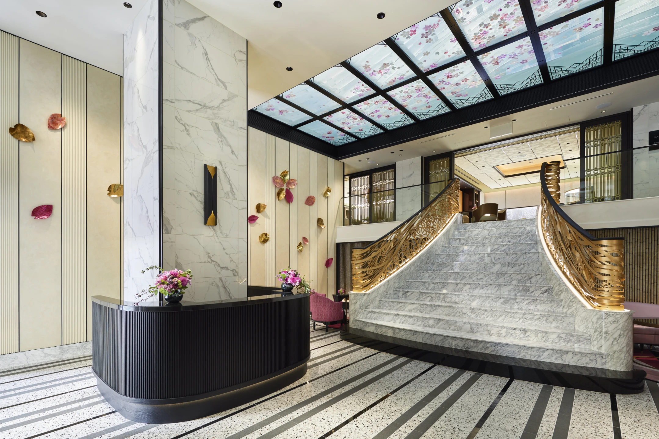 Elegant lobby of FAUCHON L’Hotel Kyoto featuring a grand staircase, marble accents, and floral decor on walls and ceiling.