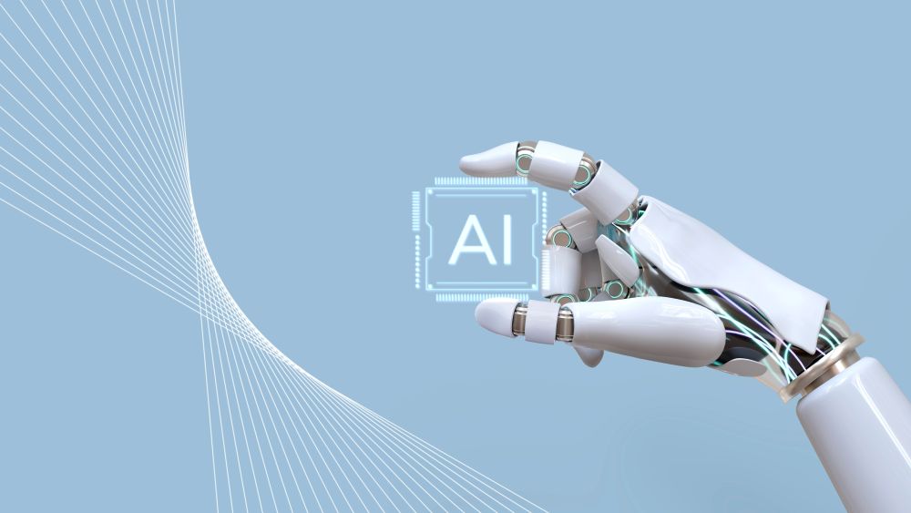 A robotic hand holding a chip marked 'AI' against a light blue background, symbolizing advancements in artificial intelligence.
