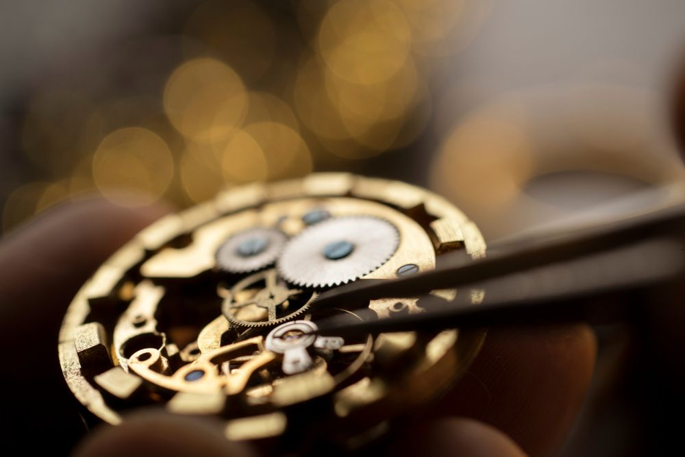A close-up view of intricate watch gears and components being adjusted with tweezers, highlighting luxury craftsmanship.