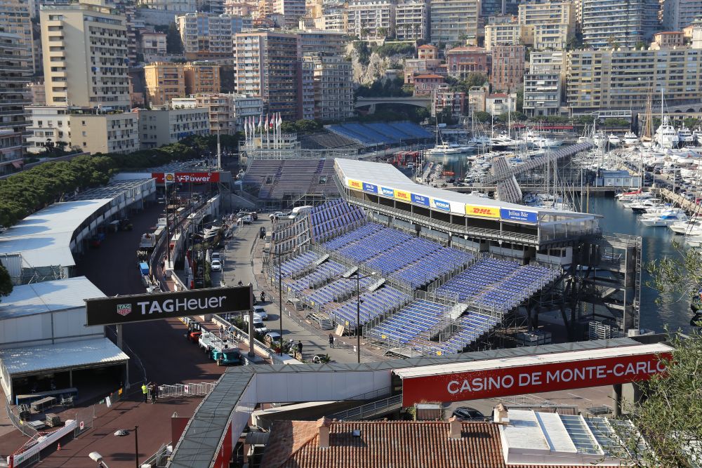 View of the Monaco Grand Prix circuit featuring the stands, marina, and iconic Casino de Monte-Carlo in the background.