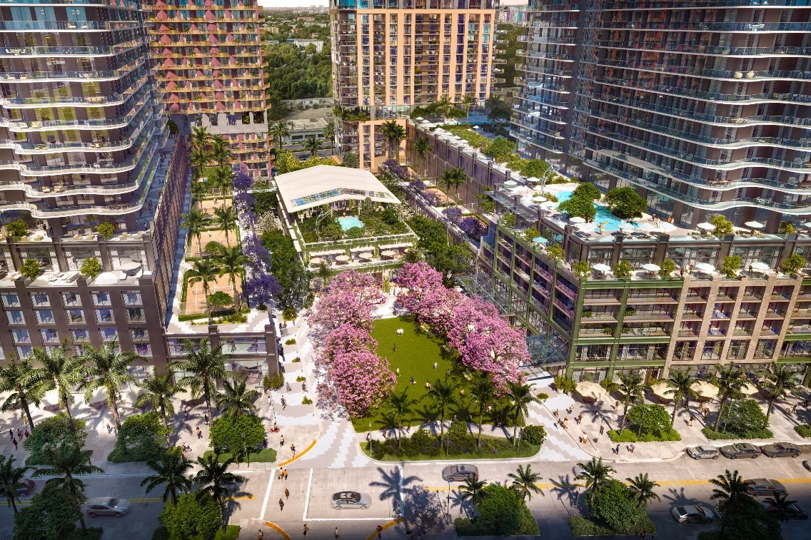 Aerial view of a vibrant urban development in Midtown Miami featuring landscaped gardens, pools, and modern high-rise buildings.