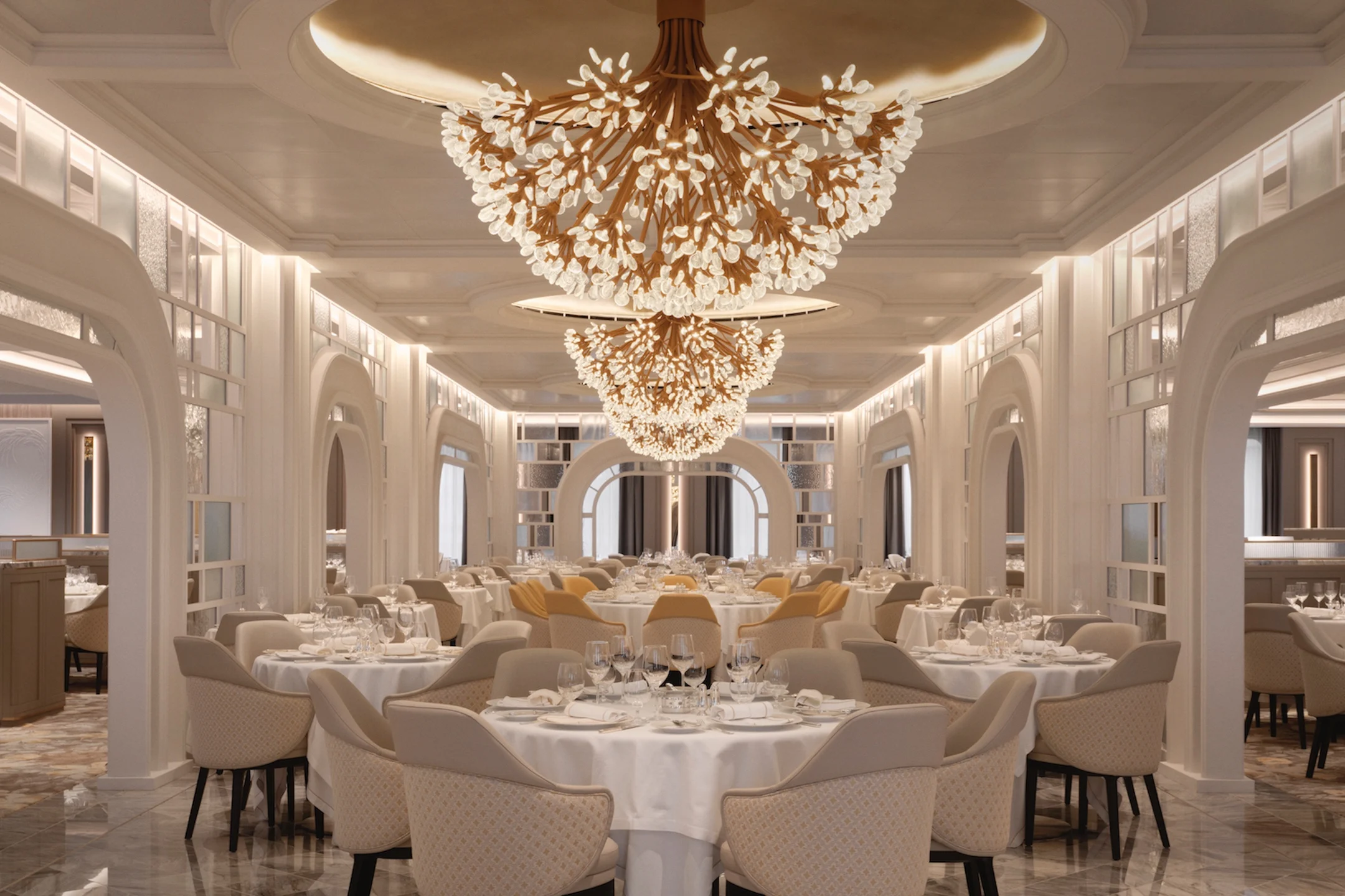 Elegant dining room featuring ornate chandeliers, beautifully set tables, and stylish seating arrangements.
