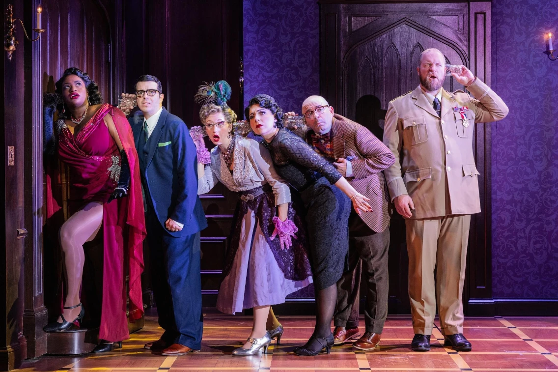 A diverse group of six characters gather in suspense at a mysterious doorway during a theatrical performance.