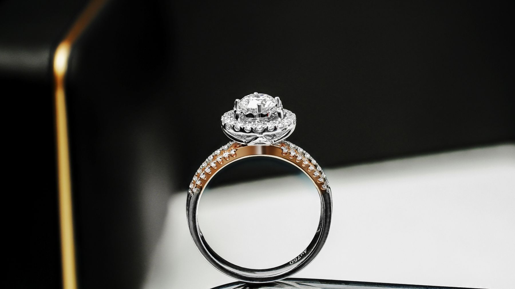 Engagement ring featuring a round center diamond and intricate detailing on a dual-tone band.