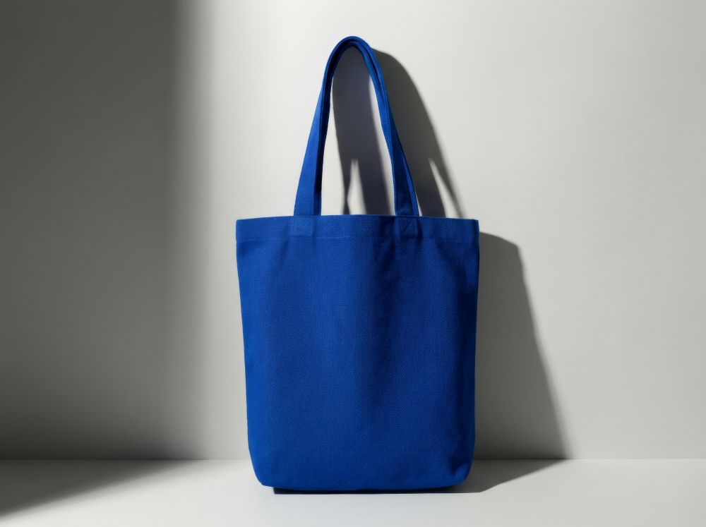 Bright blue canvas tote bag with two handles, displayed against a light background.