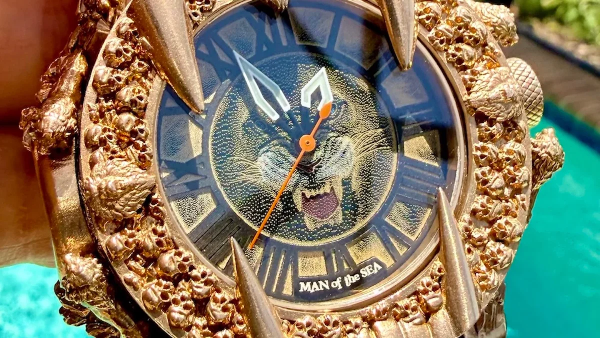 Gold wristwatch featuring a fierce lion design and intricate detailing on the bezel, titled "MAN of the SEA."