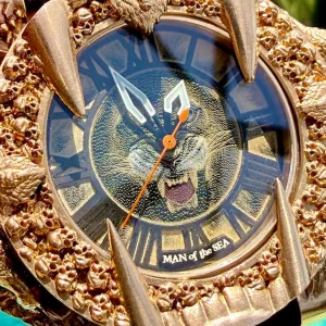 Gold wristwatch featuring a fierce lion design and intricate detailing on the bezel, titled "MAN of the SEA."