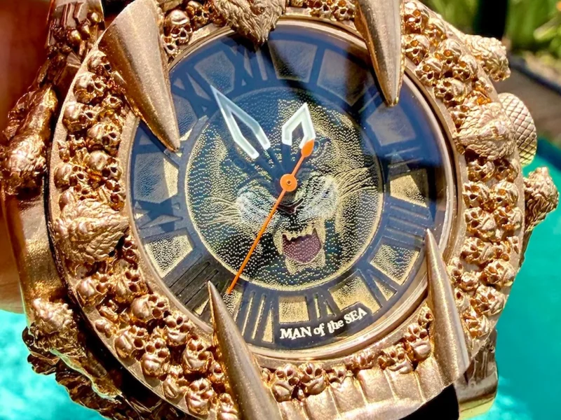 Gold wristwatch featuring a fierce lion design and intricate detailing on the bezel, titled "MAN of the SEA."