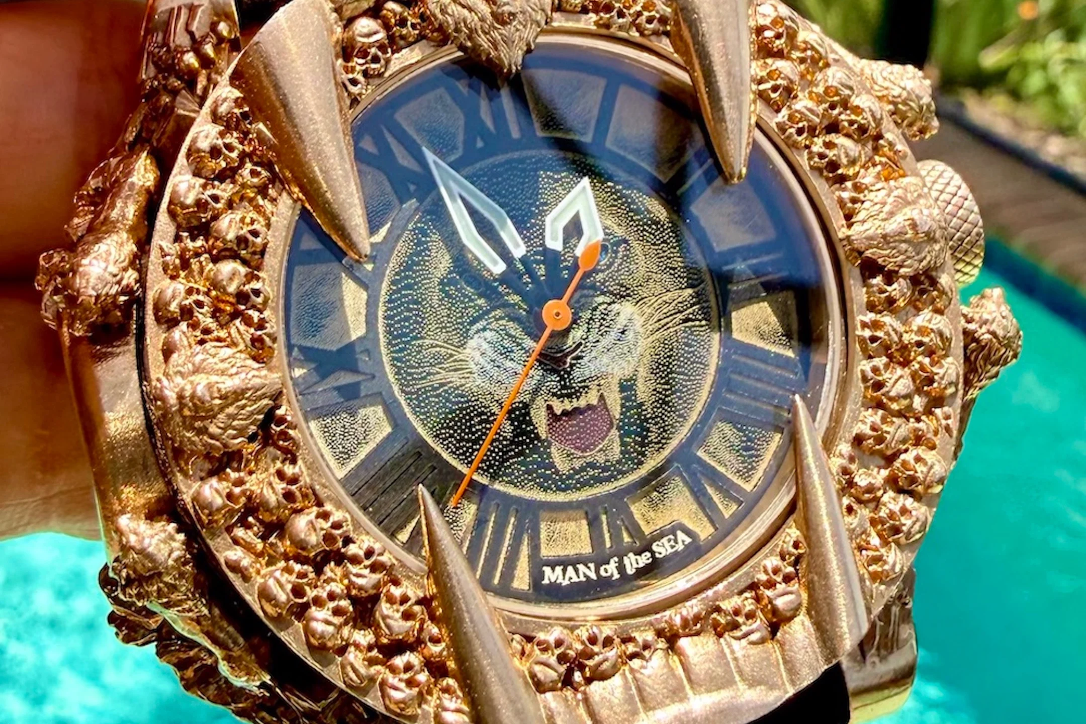 Gold wristwatch featuring a fierce lion design and intricate detailing on the bezel, titled "MAN of the SEA."
