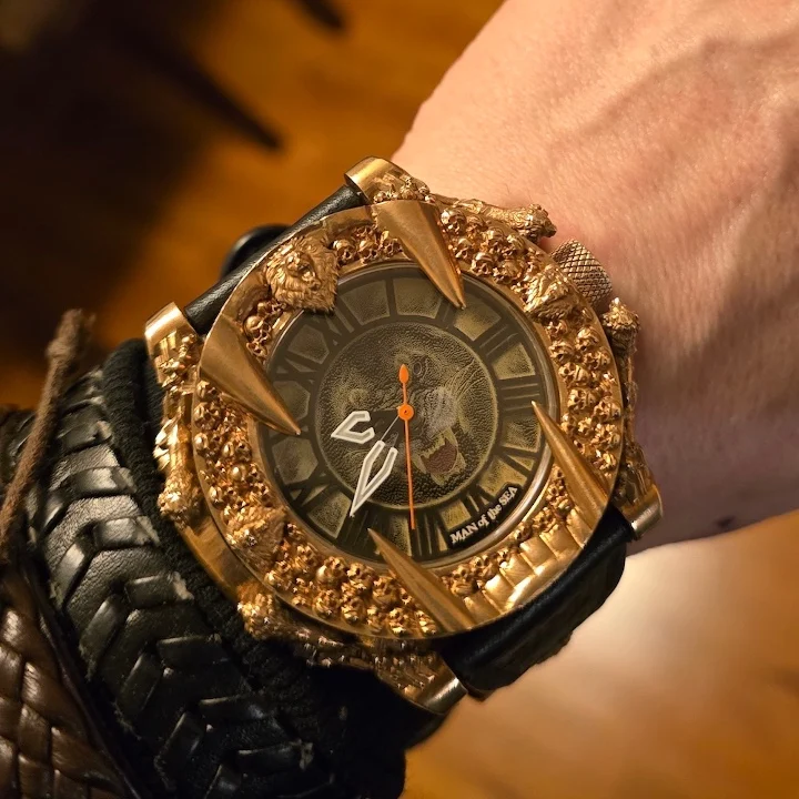Gold and black wristwatch featuring a lion motif, bold spikes, and an intricate design on the dial.