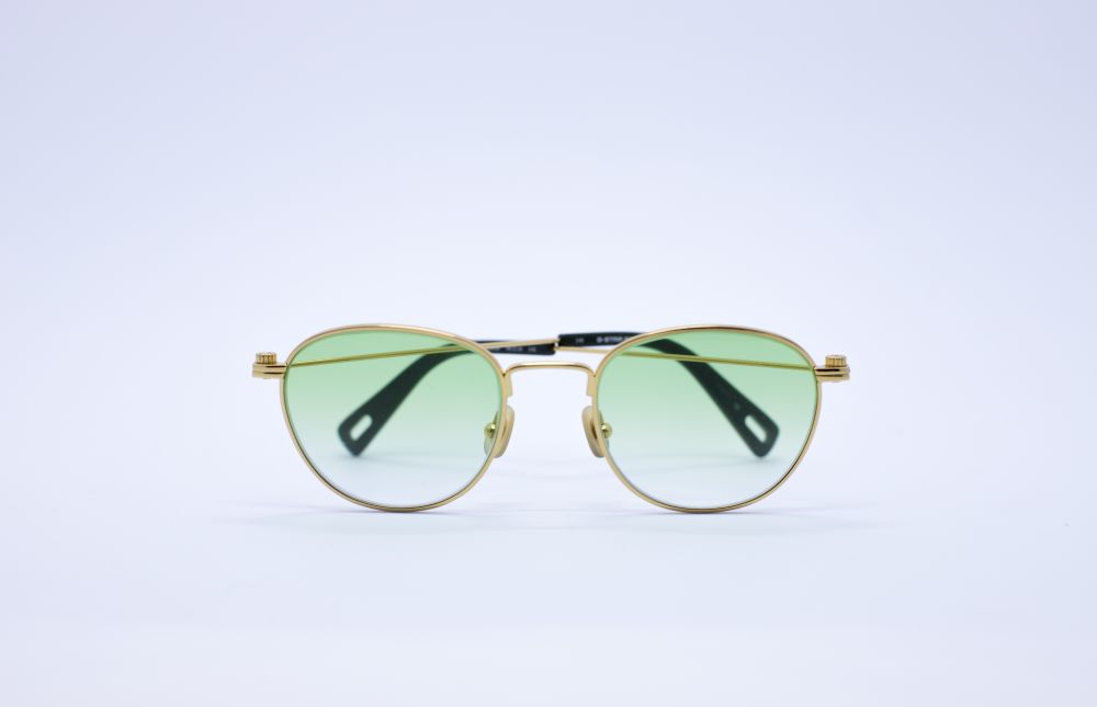 Gold-framed sunglasses with green lenses, showcasing a chic and stylish design ideal for women's fashion.