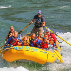 A group of people enjoying a thrilling white-water rafting experience on the Mad River.